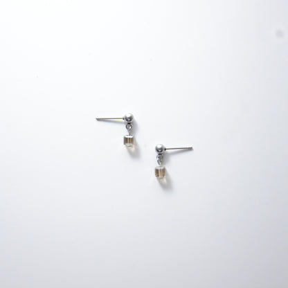 Pair of silver stainless steel ball stud earrings with sugar cube gray glass beads on a white background