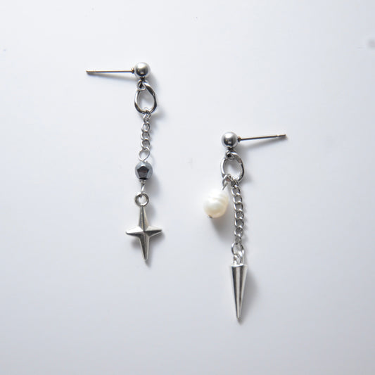 Pair of silver stainless steel ball stud drop earrings with a chain and star charm and a pearl and spike charm on a white background