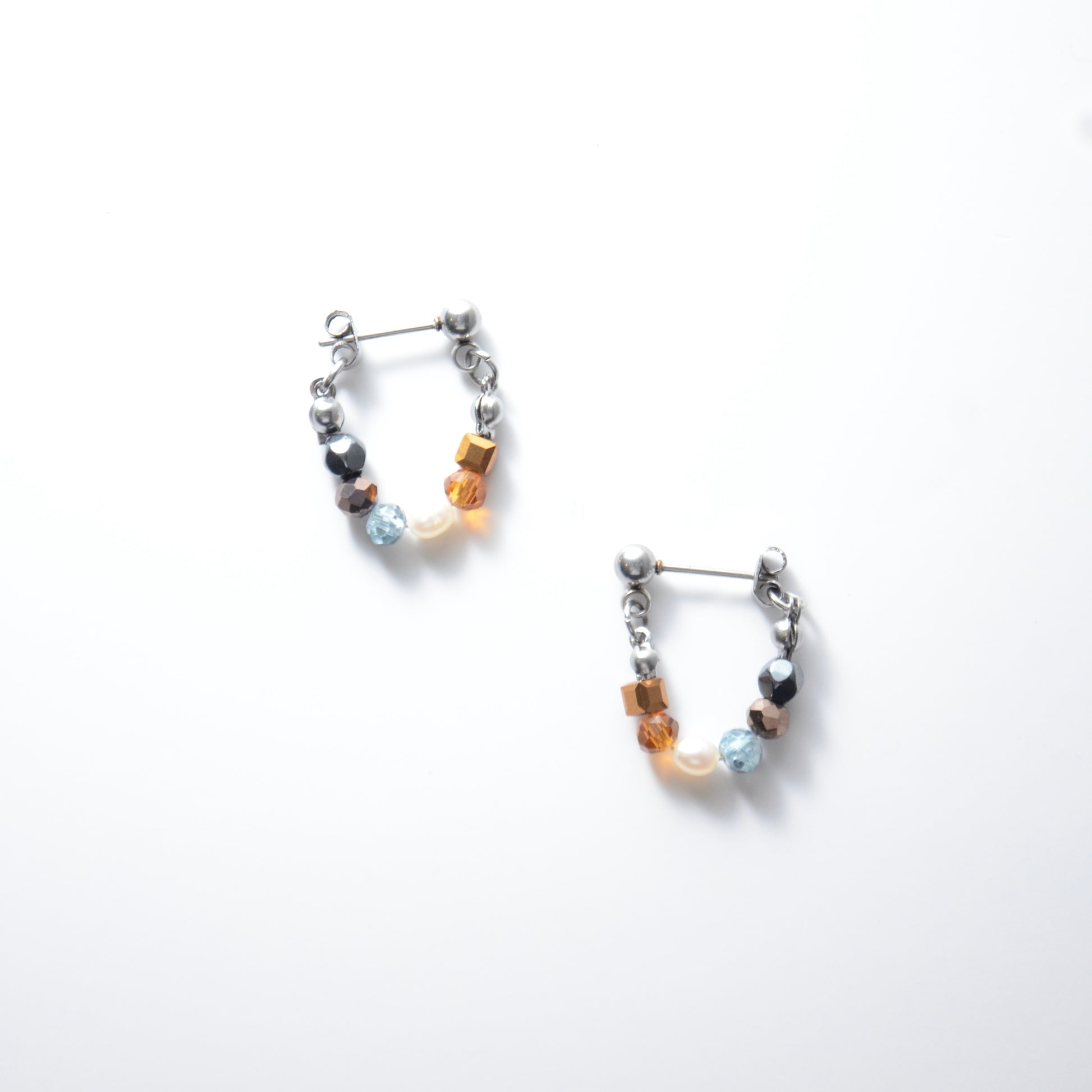 Pair of stainless steel beaded hoop earrings on a white background