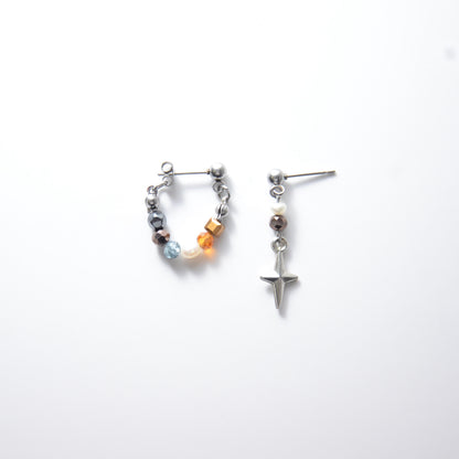 Pair of stainless steel hoop earrings with small beads and drop earrings with star charm on a white background
