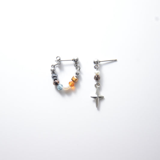Pair of stainless steel hoop earrings with small beads and drop earrings with star charm on a white background