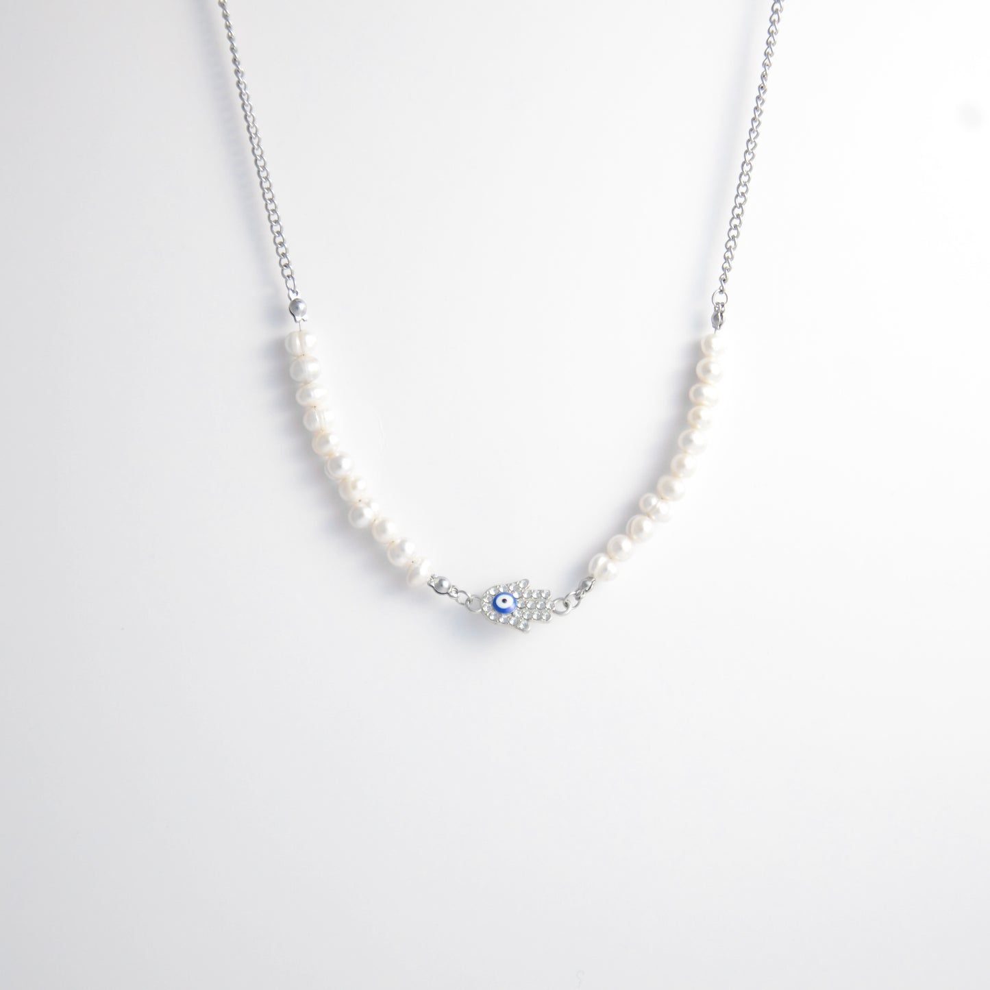 Silver stainless steel pearl choker necklace with a silver hand evil eye pendant on a light gray background