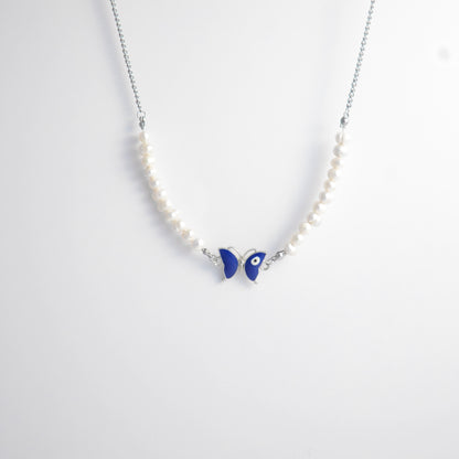 Silver stainless steel pearl choker necklace with a blue butterfly evil eye pendant on a light gray background