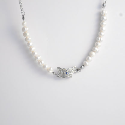 Silver stainless steel pearl choker necklace with a silver butterfly evil eye pendant on a light gray background