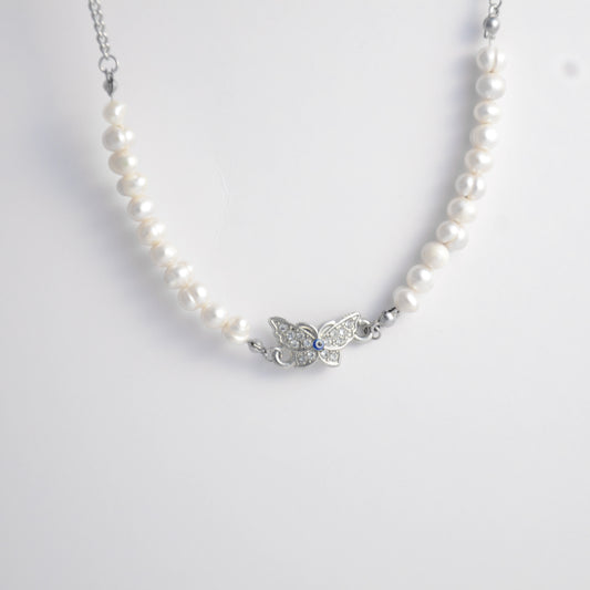 Silver stainless steel pearl choker necklace with a silver butterfly evil eye pendant on a light gray background