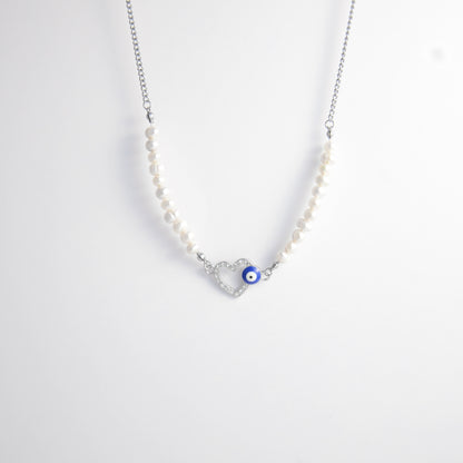 Silver stainless steel pearl choker necklace with a silver heart evil eye pendant on a light gray background