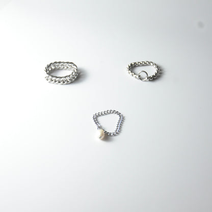 Three silver stainless steel chain rings with pearl charm on a white background