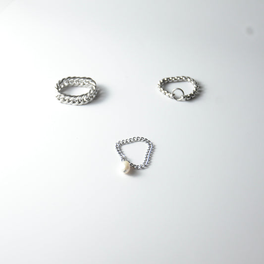Three silver stainless steel chain rings with pearl charm on a white background