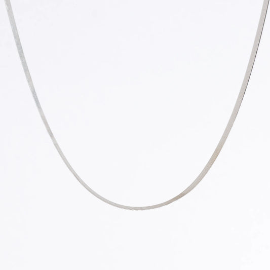 Silver herringbone chain necklace on a light gray background