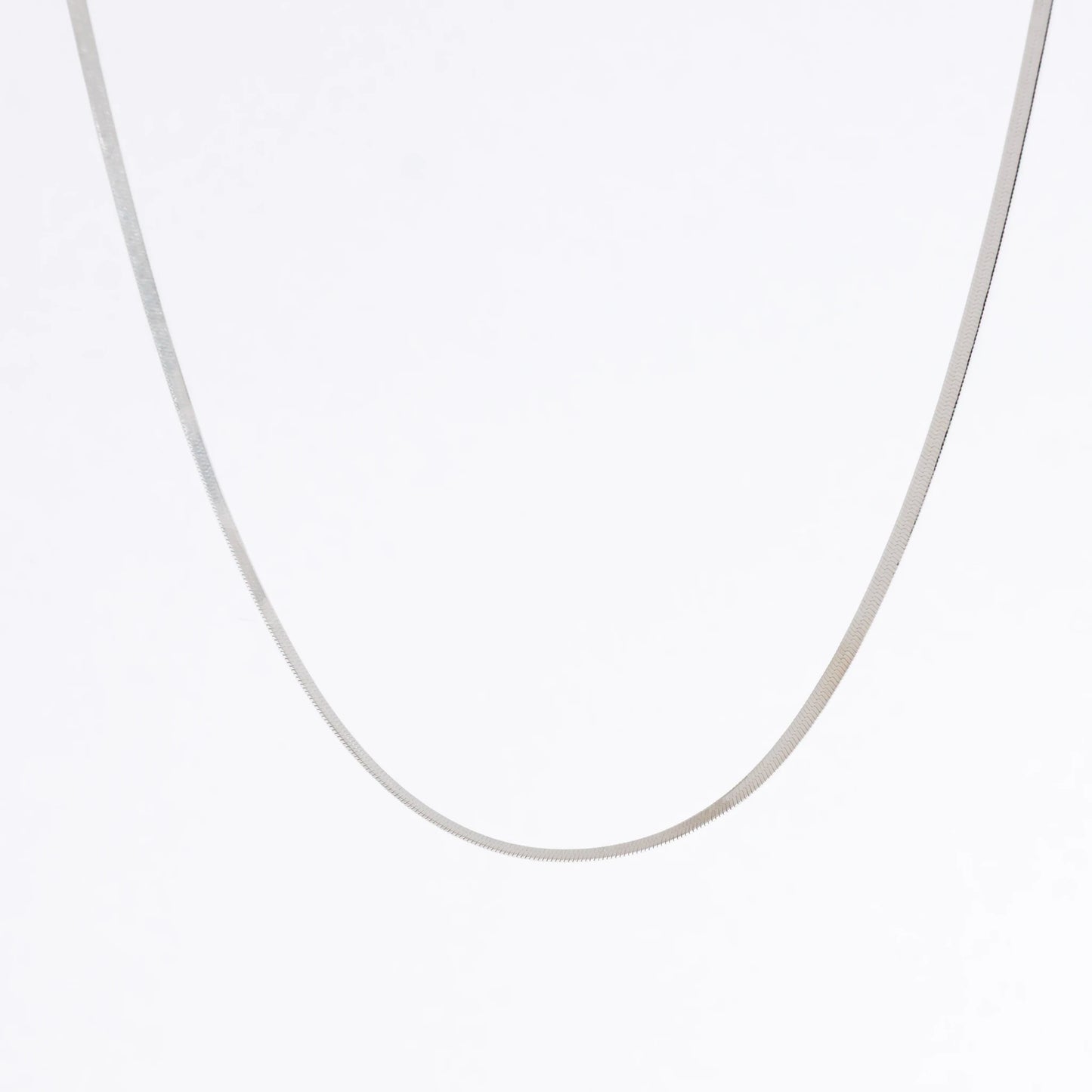 Silver herringbone chain necklace on a light gray background
