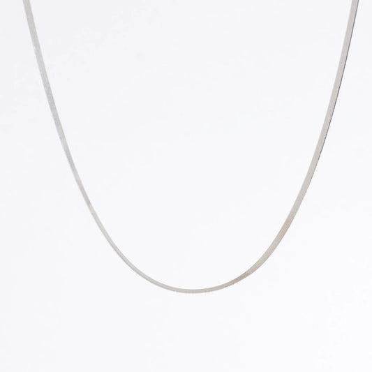 Silver herringbone chain necklace on a light gray background