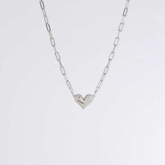 Silver heart-shaped pendant necklace on a light gray background