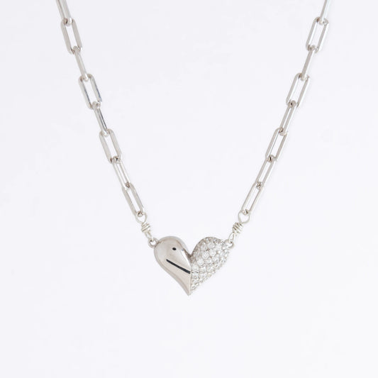Silver heart-shaped pendant necklace on a light gray background