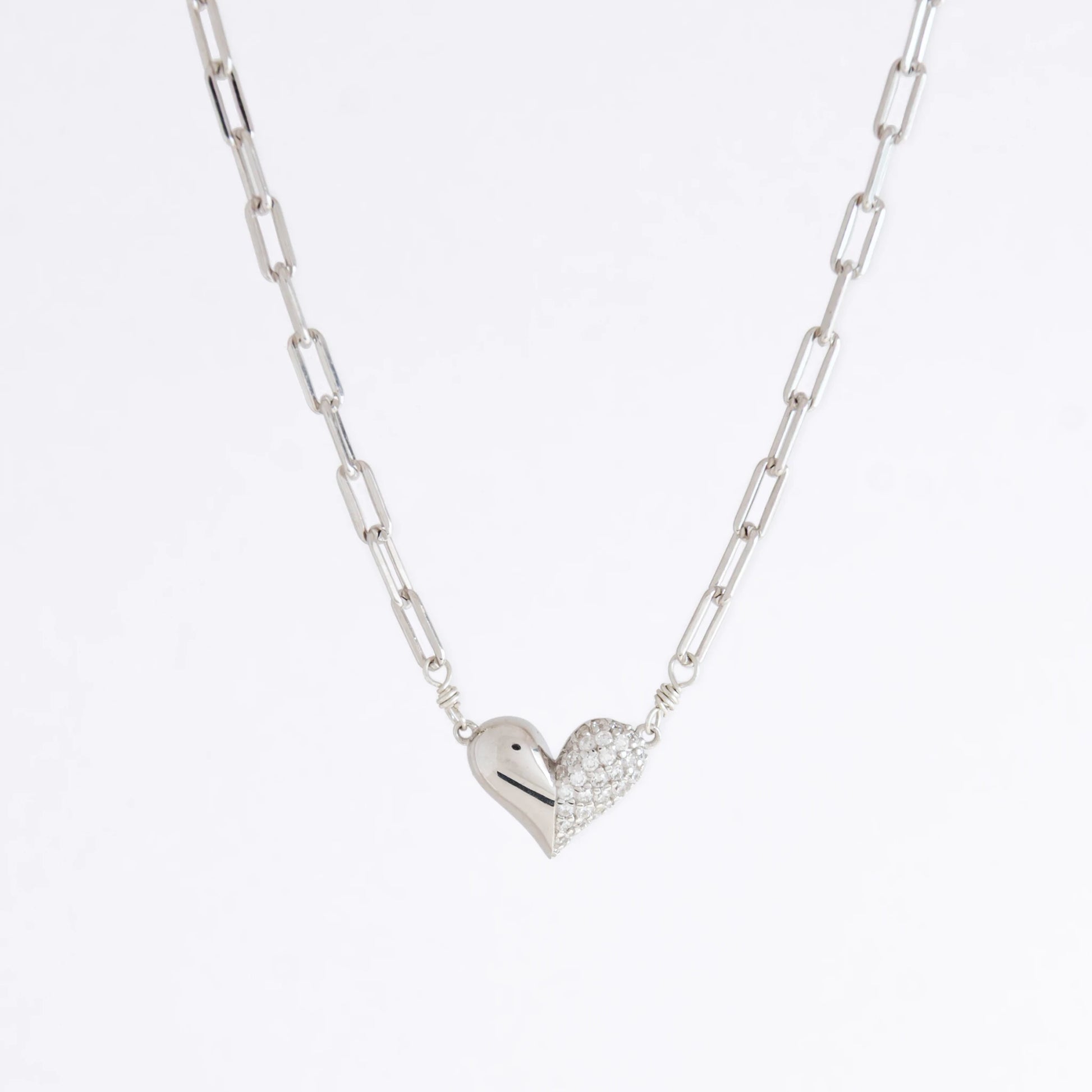 Silver heart-shaped pendant necklace on a light gray background