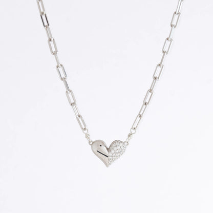Silver heart-shaped pendant necklace on a light gray background