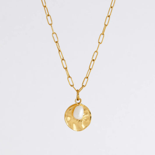 Gold paperclip necklace non-tarnish with a round sun pendant and a pearl on a light gray background