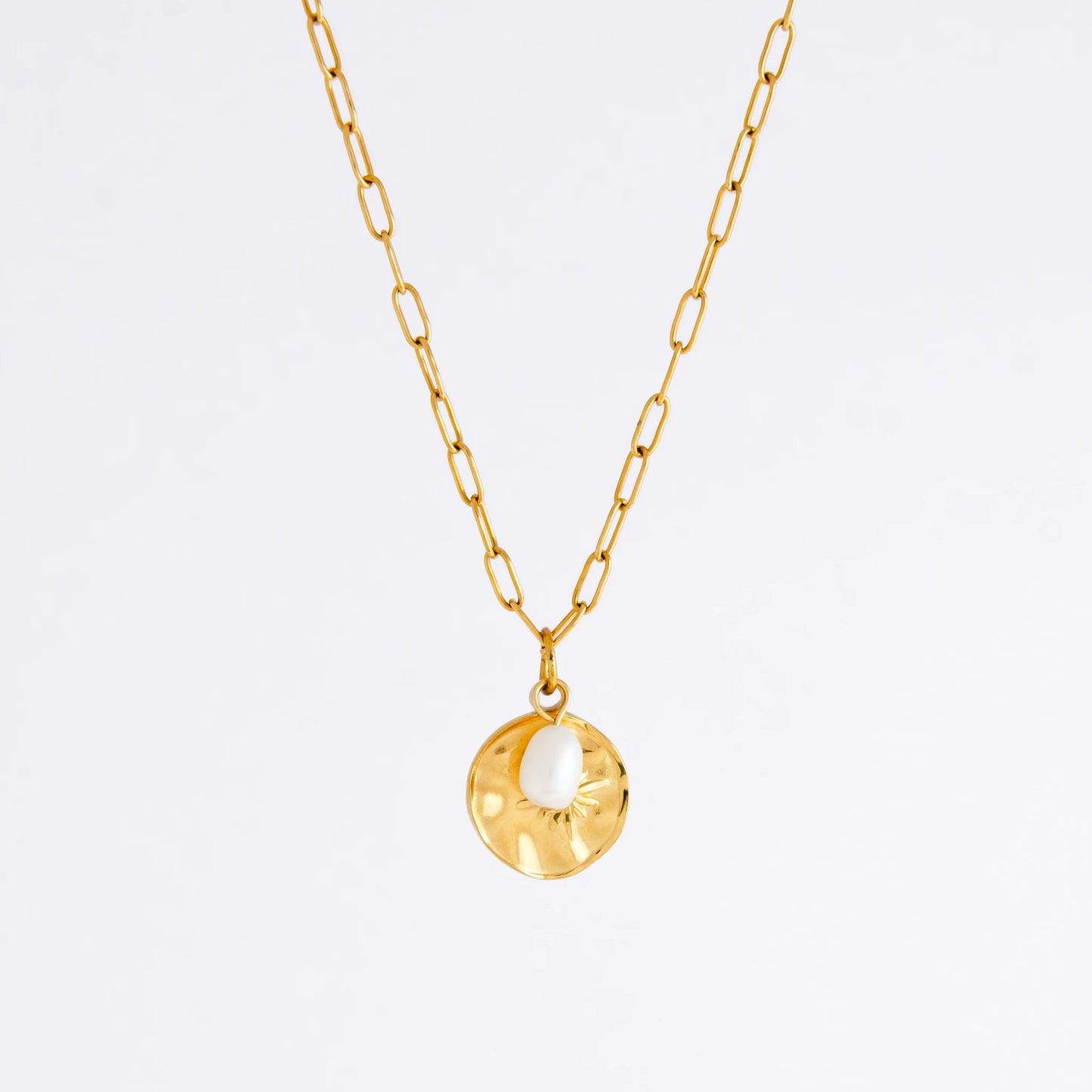 Gold paperclip necklace non-tarnish with a round sun pendant and a pearl on a light gray background