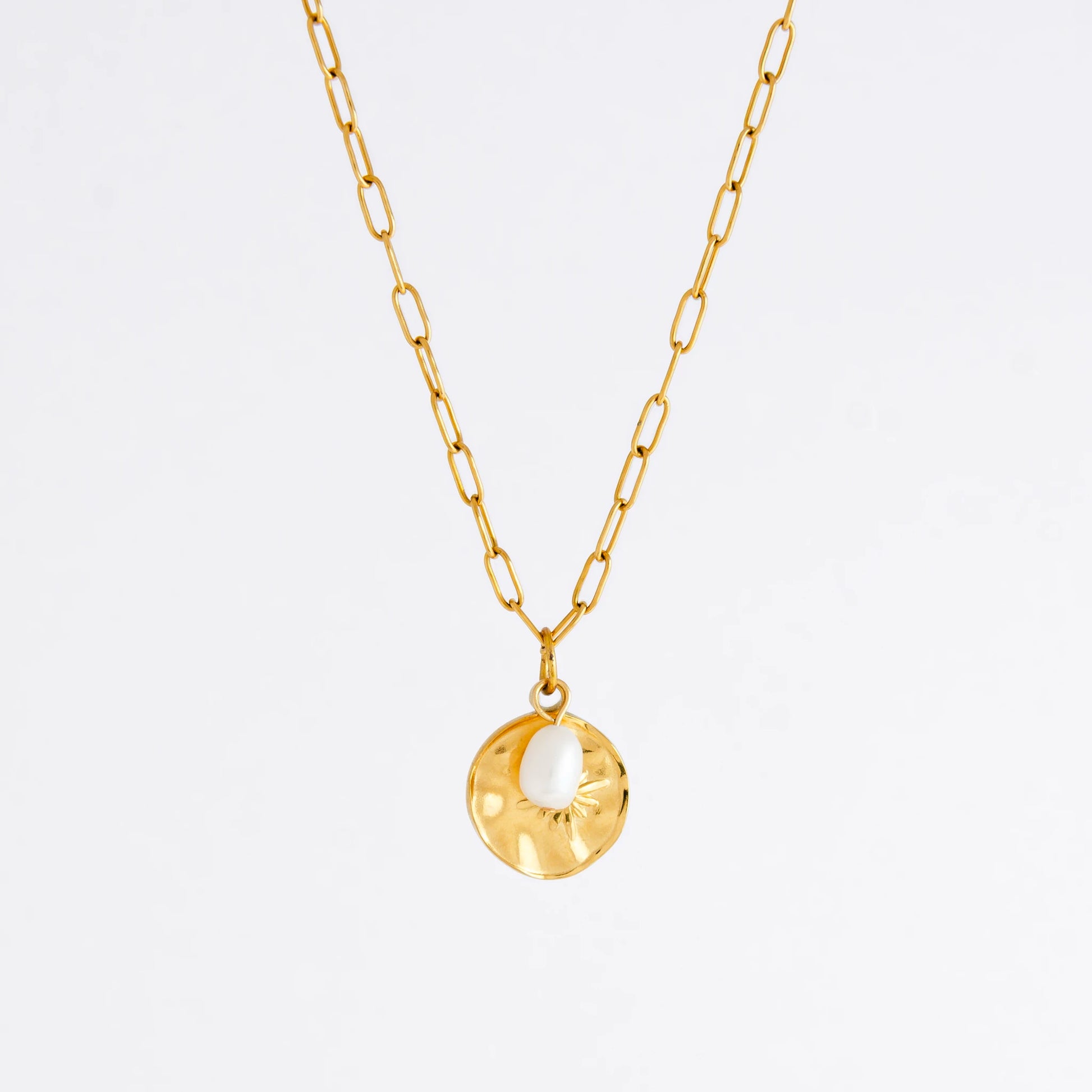 Gold paperclip necklace non-tarnish with a round sun pendant and a pearl on a light gray background