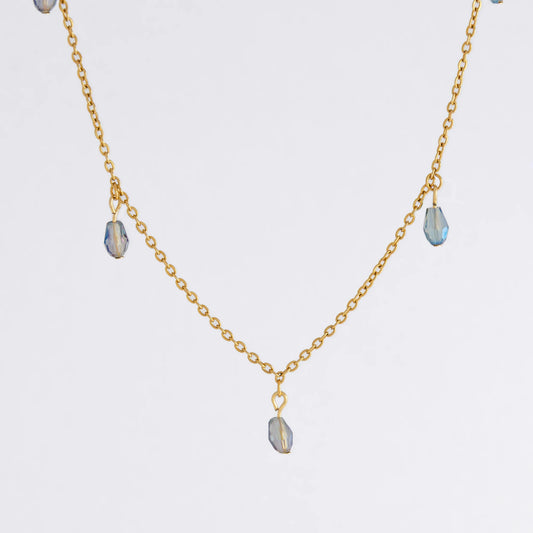 Gold satellite necklace with small purple glass beads on a light gray background