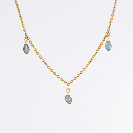 Gold satellite necklace with small purple glass beads on a light gray background