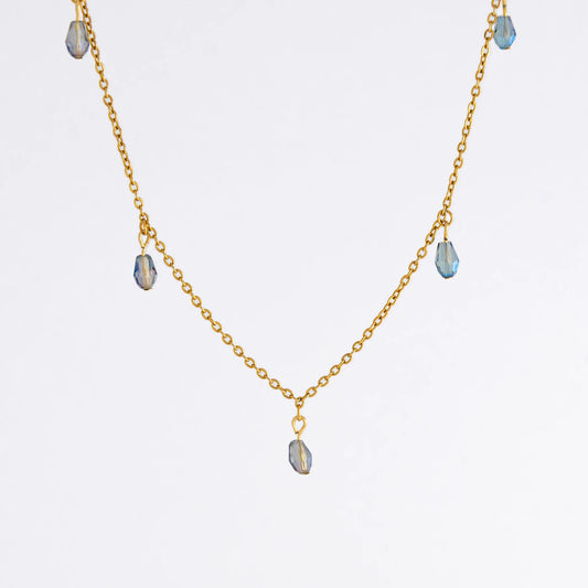 Gold satellite necklace with small purple glass beads on a light gray background