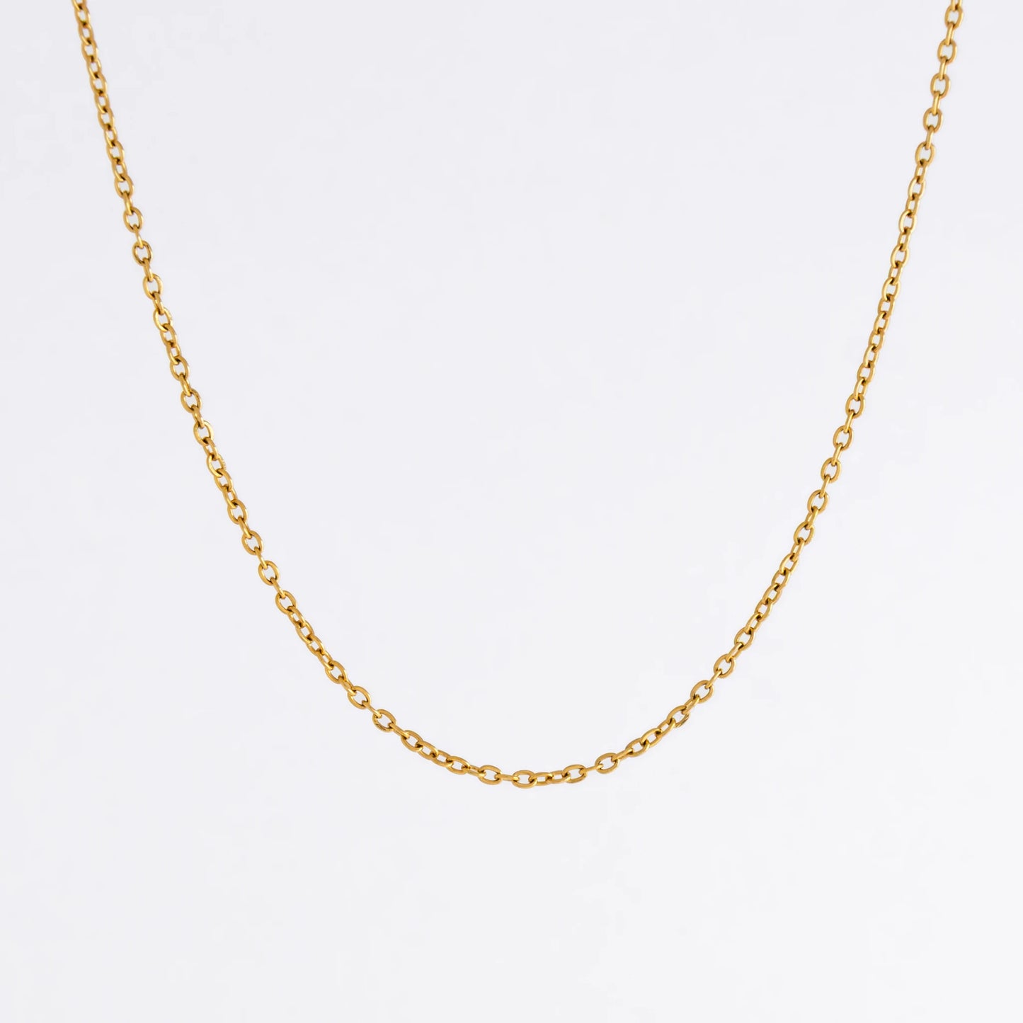 Gold chain necklace on a light gray background