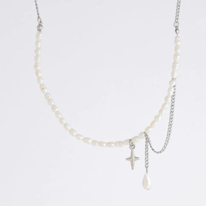 Pearl choker necklace with a small star pendant and a layering chain with pearl on a light gray background