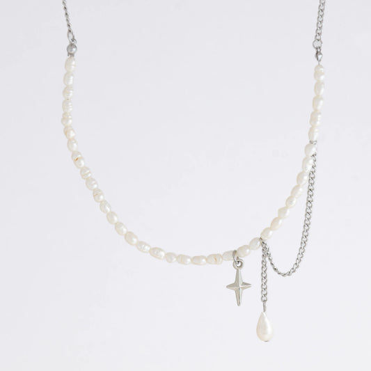 Pearl choker necklace with a small star pendant and a layering chain with pearl on a light gray background