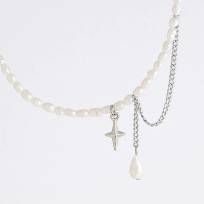 Pearl choker necklace with a small star pendant and a layering chain with pearl on a light gray background