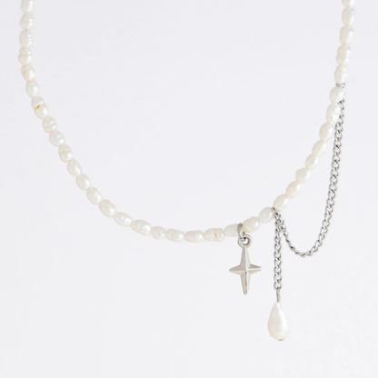 Pearl choker necklace with a small star pendant and a layering chain with pearl on a light gray background