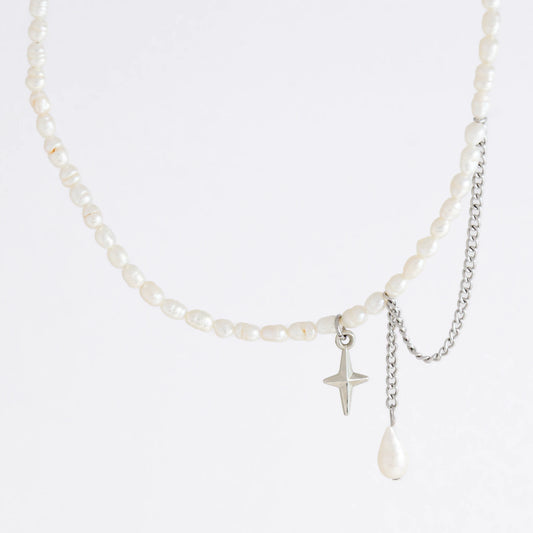 Pearl choker necklace with a small star pendant and a layering chain with pearl on a light gray background
