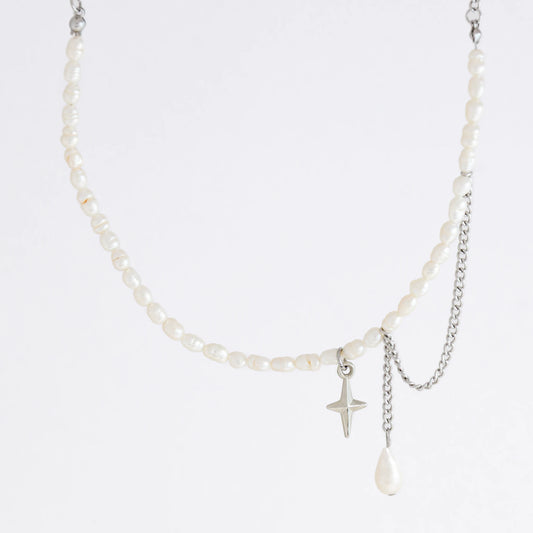Pearl choker necklace with a small star pendant and a layering chain with pearl on a light gray background