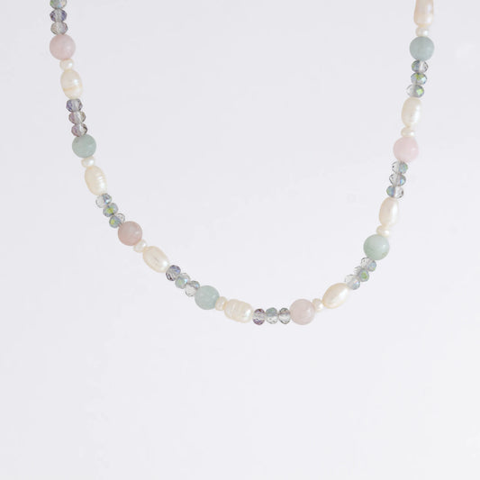 Beaded necklace with pearls and glass beads on a light gray background