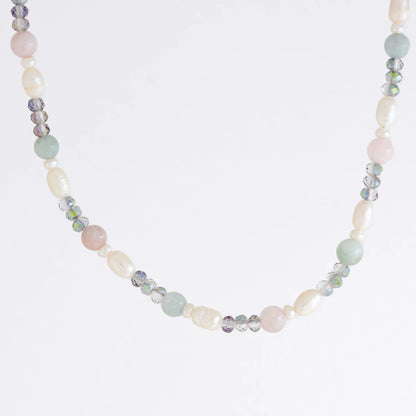 Beaded necklace with pearls and glass beads on a light gray background