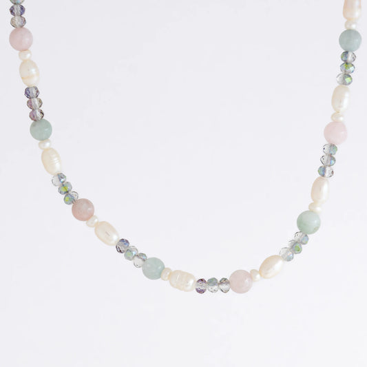 Beaded necklace with pearls and glass beads on a light gray background