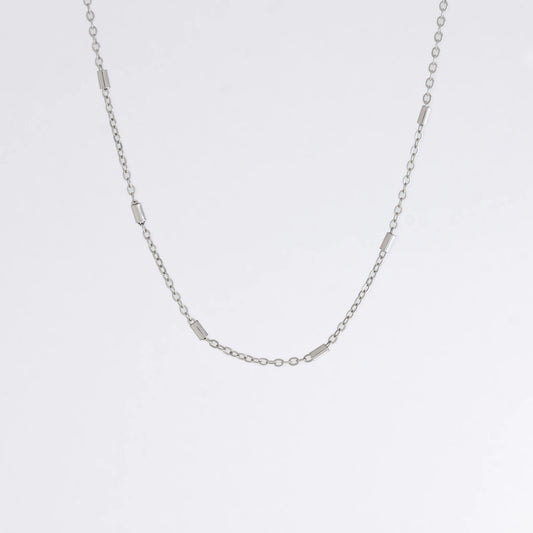 Dainty silver bar link chain for minimalistic fashion or for layering jewelry on a light gray background