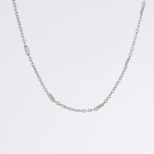 Dainty silver bar link chain for minimalistic fashion or for layering jewelry on a light gray background