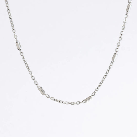 Dainty silver bar link chain for minimalistic fashion or for layering jewelry on a light gray background