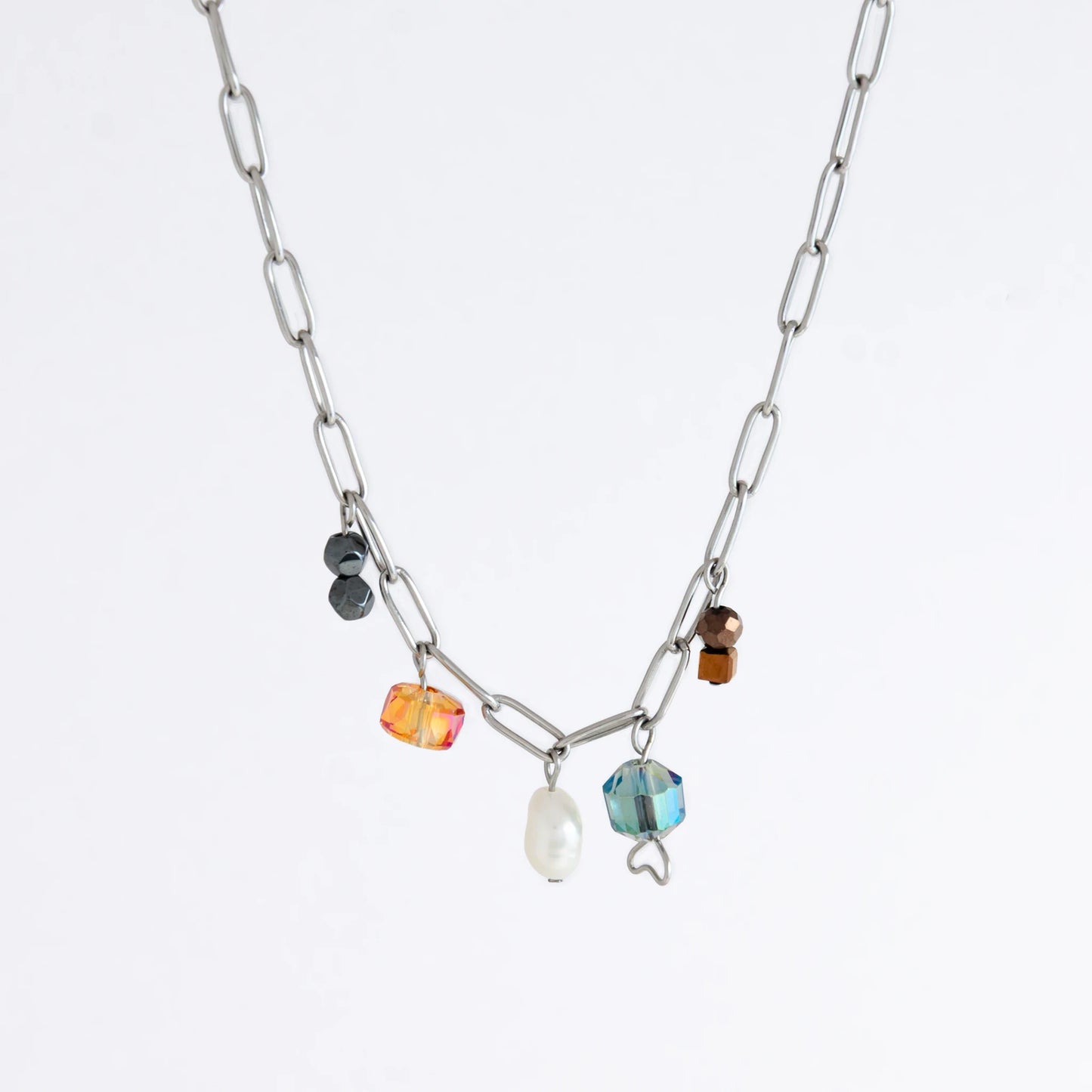 Silver paperclip chain necklace with small bead charms including freshwater pearls, black, blue, and orange glass beads on a light gray background
