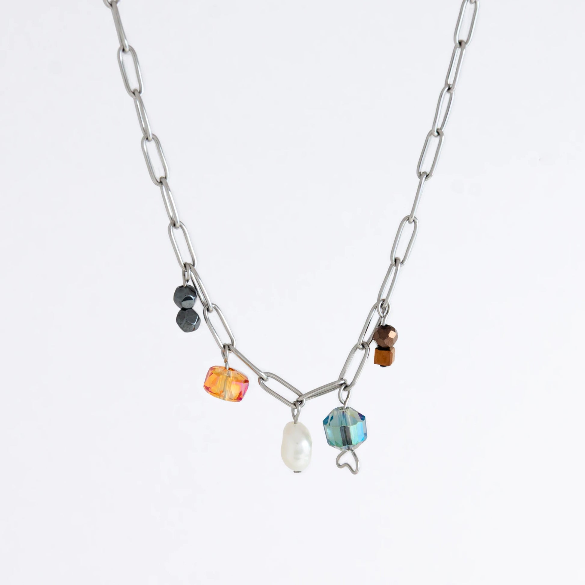 Silver paperclip chain necklace with small bead charms including freshwater pearls, black, blue, and orange glass beads on a light gray background