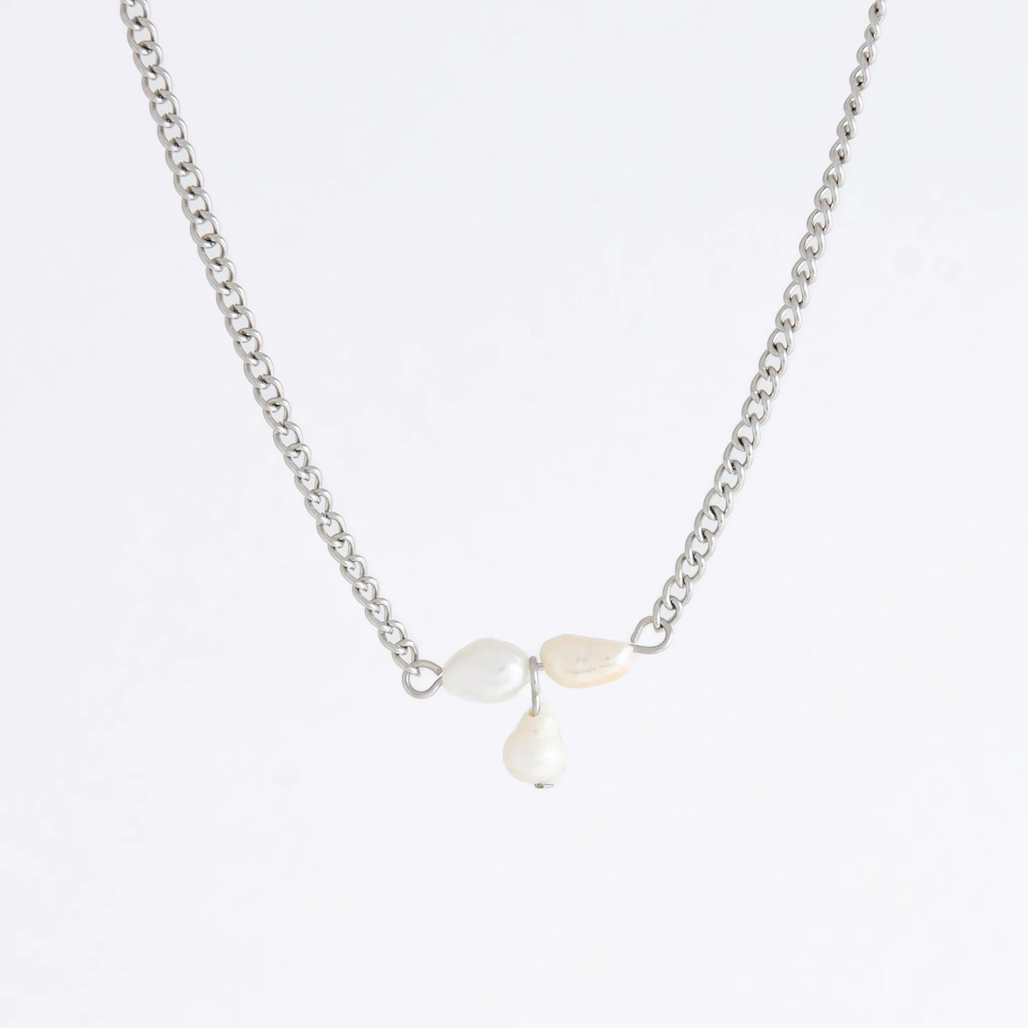 Silver necklace non-tarnish with three pearl beads on a light gray background