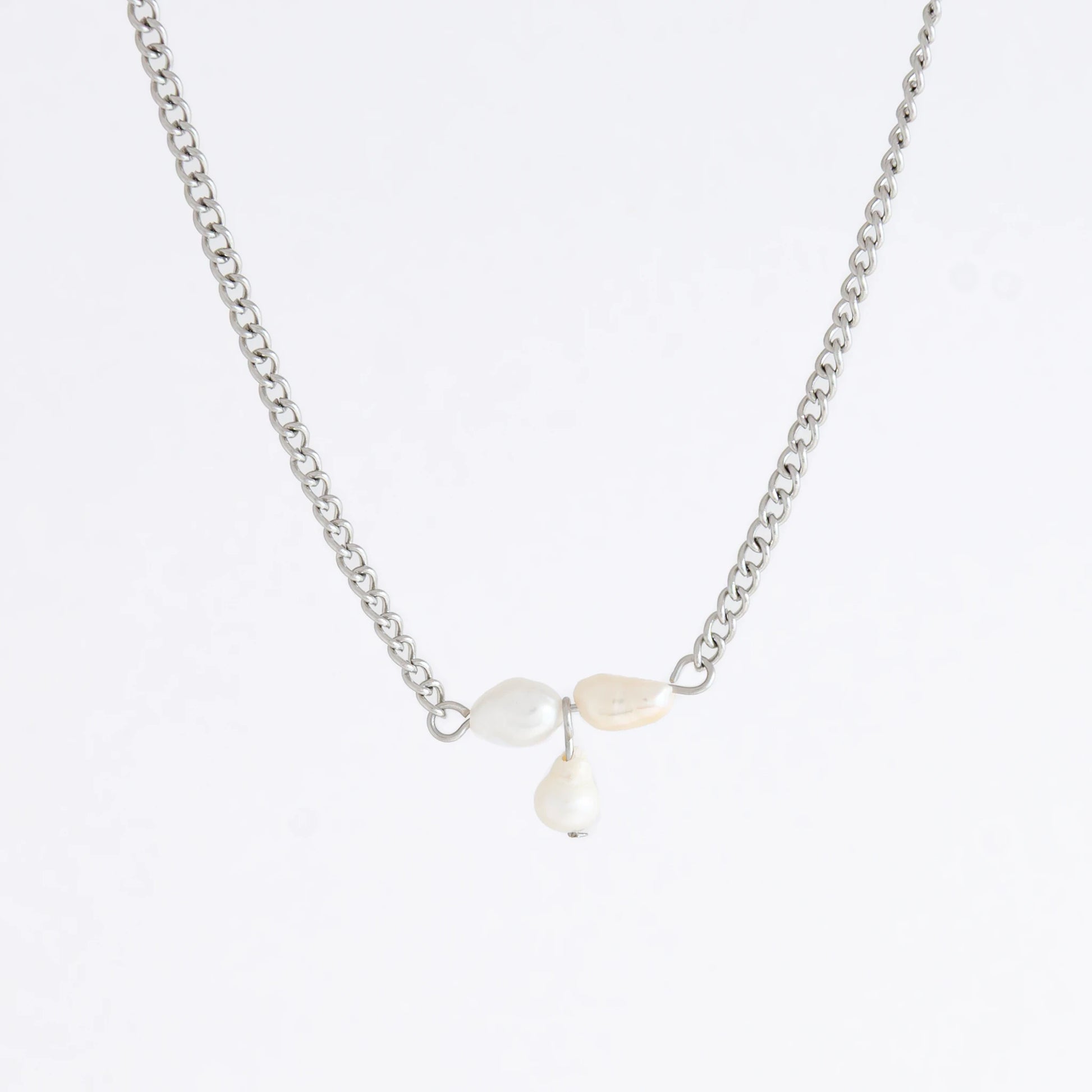 Silver necklace non-tarnish with three pearl beads on a light gray background