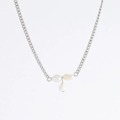 Silver necklace non-tarnish with three pearl beads on a light gray background