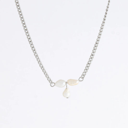 Silver necklace non-tarnish with three pearl beads on a light gray background