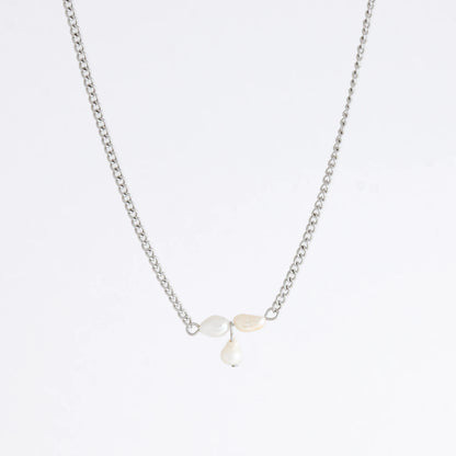 Silver necklace non-tarnish with three pearl beads on a light gray background