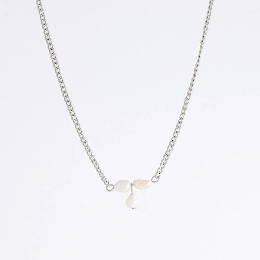Silver necklace non-tarnish with three pearl beads on a light gray background