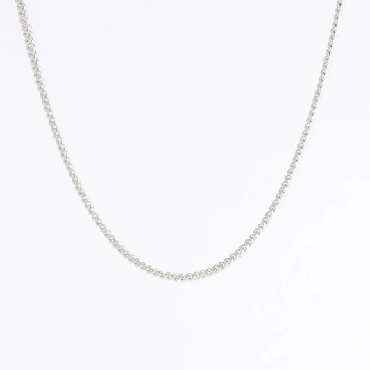 Dainty silver curb chain for minimalistic fashion or for layering jewelry on a light gray background