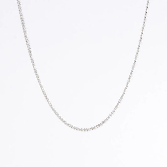 Dainty silver curb chain for minimalistic fashion or for layering jewelry on a light gray background