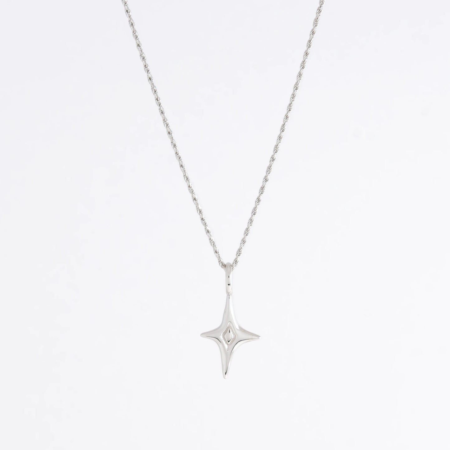 Silver star-shaped pendant necklace on a light gray background