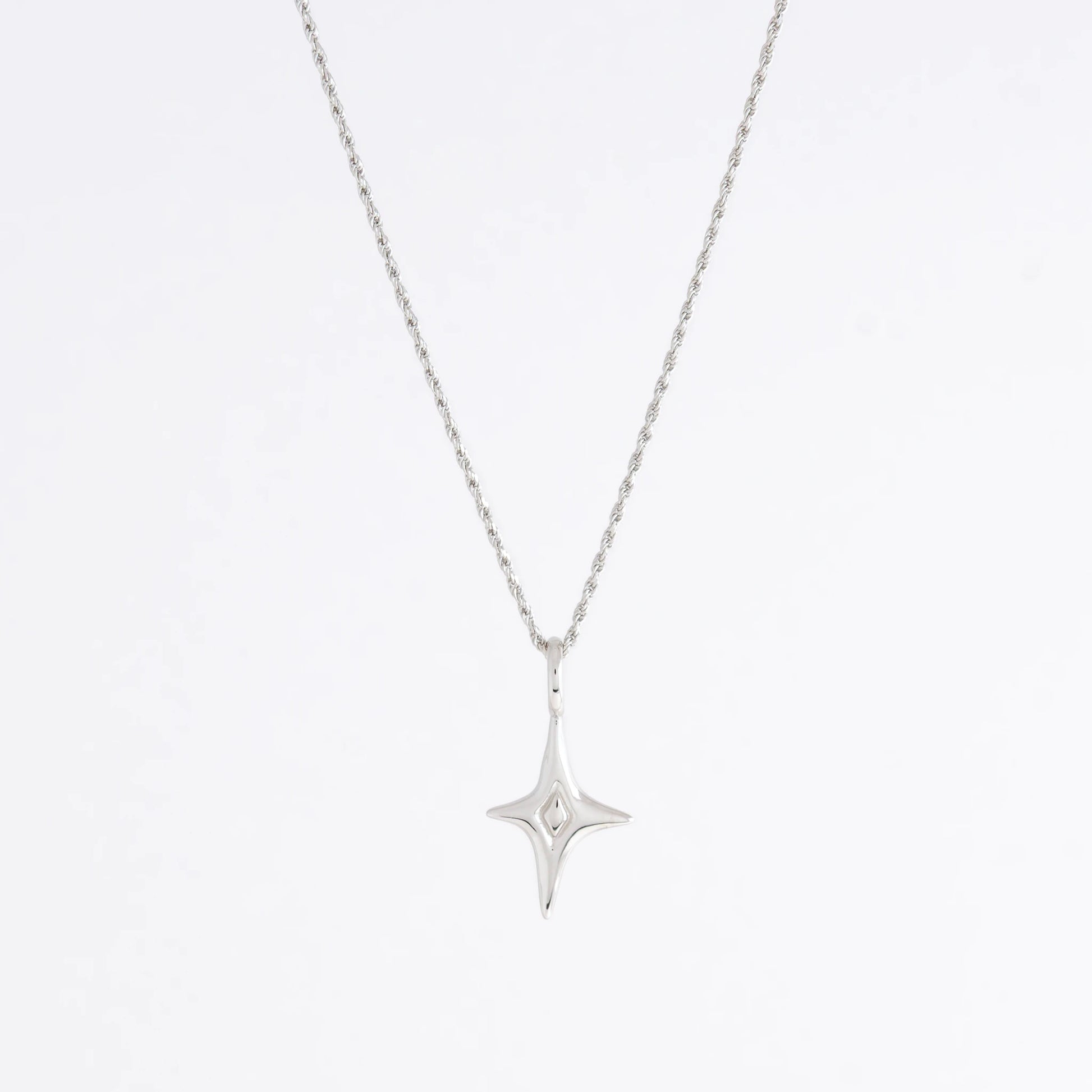 Silver star-shaped pendant necklace on a light gray background